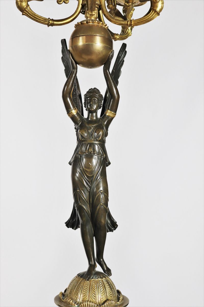 Coppia di grandi candelabri con sculture di "Vittorie alate" in bronzo patinato e dorato