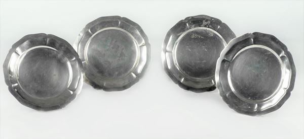 Four small silver plates with arched edges