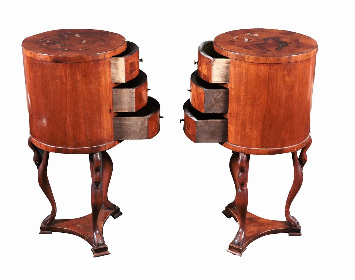 Coppia di comodini "a tamburo" in noce sorretti da tre sculture di cigni