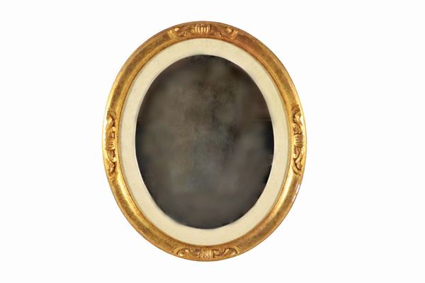 Specchiera ovale in legno dorato ed intagliato