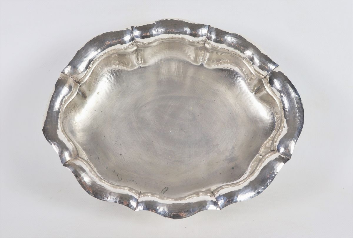 Antica fruttiera in argento martellato a forma ovale centinata e baccellata sorretta da quattro p...