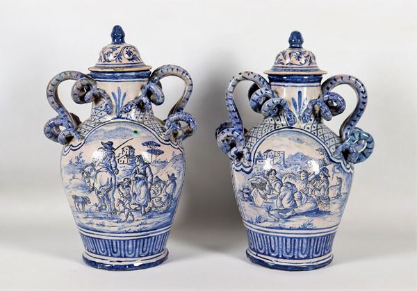 Pair of two-handled vases with lids in glazed majolica from Savona decorated in blue monochrome with peasant scenes and landscapes, handles in the shape of intertwined snakes