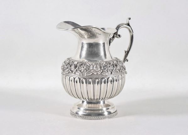 Pitcher in chiseled and embossed silver with pods motifs and floral garland, curved handle gr. 960