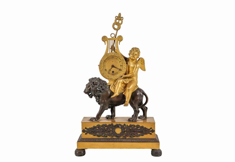 Pendola da tavolo Impero in bronzo dorato e patinato con sculture di "Putto e leone" e quadrante ...