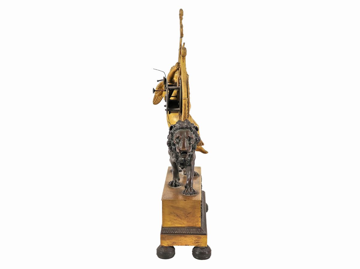 Pendola da tavolo Impero in bronzo dorato e patinato con sculture di "Putto e leone" e quadrante ...