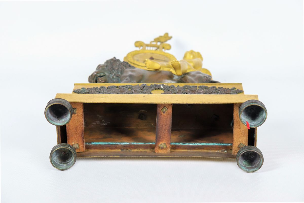 Pendola da tavolo Impero in bronzo dorato e patinato con sculture di "Putto e leone" e quadrante ...