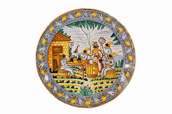 Large plate called "a capone" in glazed majolica (Neapolitan factory of Ponte della Maddalena or Borgo Loreto) with "Banchetto di Pulcinelli" in the center