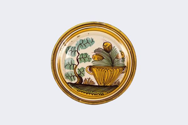 Laterza glazed majolica wall plate with colorful decorations and vase with flowers and tree in the center