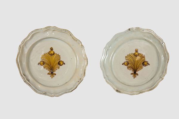 Coppia di piatti in maiolica smaltata con decoro centrale a motivo di palmette in giallo antico