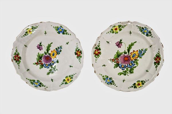 Pair of wall plates in glazed majolica decorated with polychrome flowers