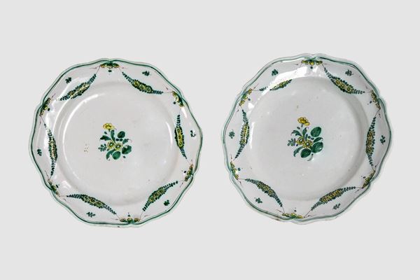 Pair of glazed majolica wall plates with green floral garland decorations