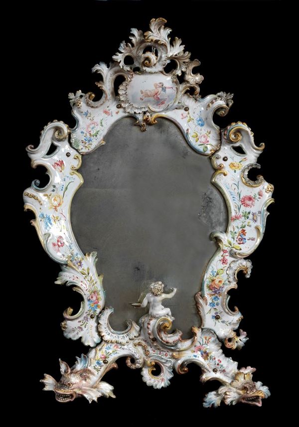 Antica specchiera in maiolica smaltata "Le Nove" Bassano decorata e variopinta a motivi di ghirlande floreali, statuina di putto e teste di draghi, specchio al mercurio