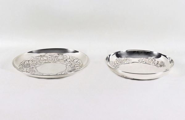 Two round centerpieces in chiseled and embossed silver with flower motifs and fruit garlands gr. 530