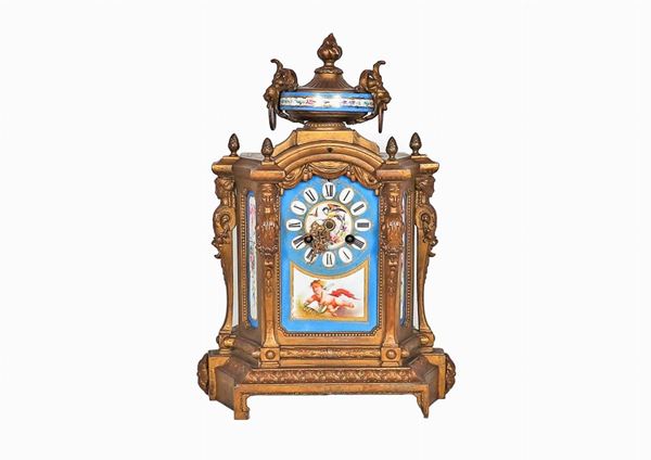 Antique French table clock in gilt bronze, embossed and chiseled with polychrome Sevres porcelain plaques decorated with cherubs motifs and floral garlands