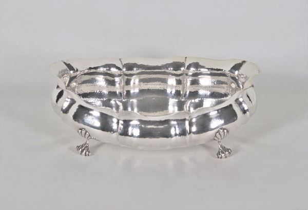 Fruit bowl in hammered silver in an oval shape, supported by four feet in the shape of shells gr. 680