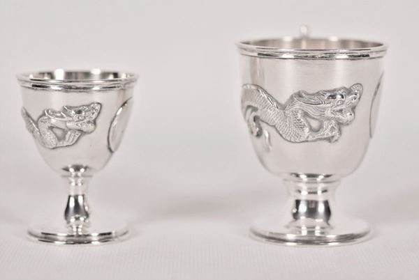 Lot in Chinese silver of a small glass with handle and an egg cup with embossed dragons figures gr. 115