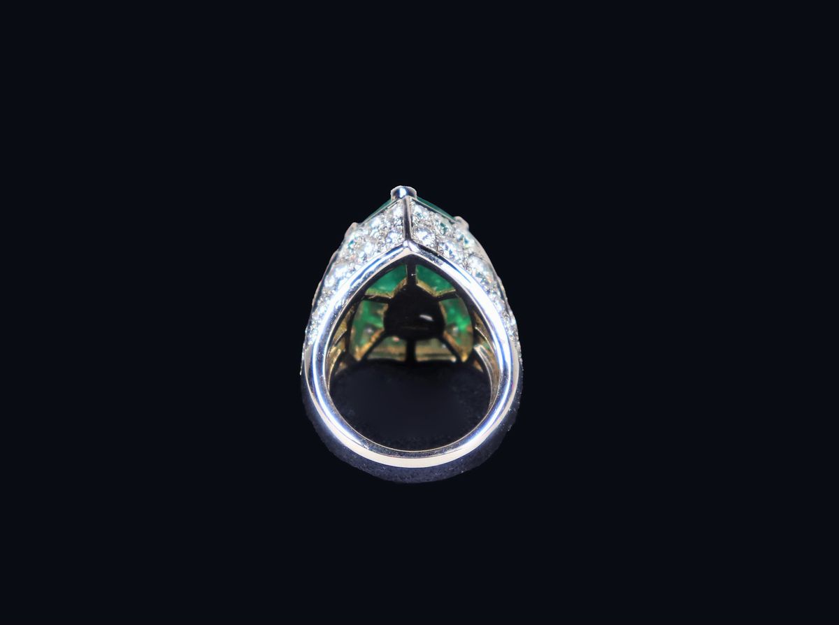 Anello in oro bianco 750 modellato a fascia, incastonato con smeraldo centrale a goccia contornat...
