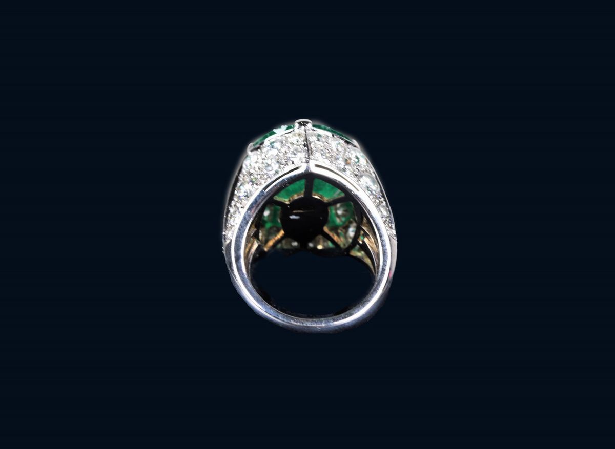 Anello in oro bianco 750 modellato a fascia, incastonato con smeraldo centrale a goccia contornat...
