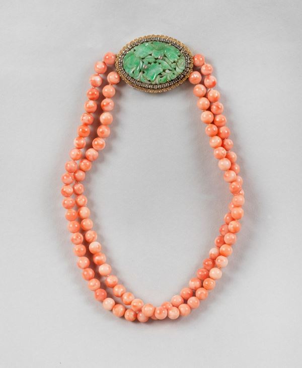 Collana girocollo a 2 fili di coralli rosa con chiusura gioiello in oro giallo 750 con giada incisa contornata da diamantini. Lunghezza cm 41.