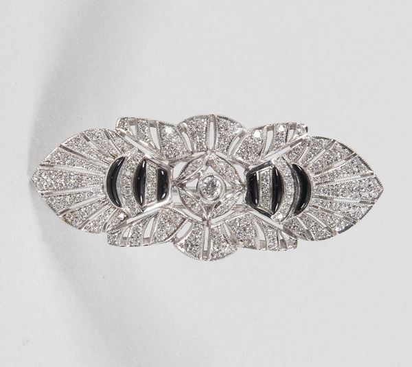 Spilla in oro bianco 750 disegno Decò con serie di brillanti e smalti, utilizzabile anche come fermezza per collana a tre fili. Gr. 22,10 circa - Ct 1,90 circa.