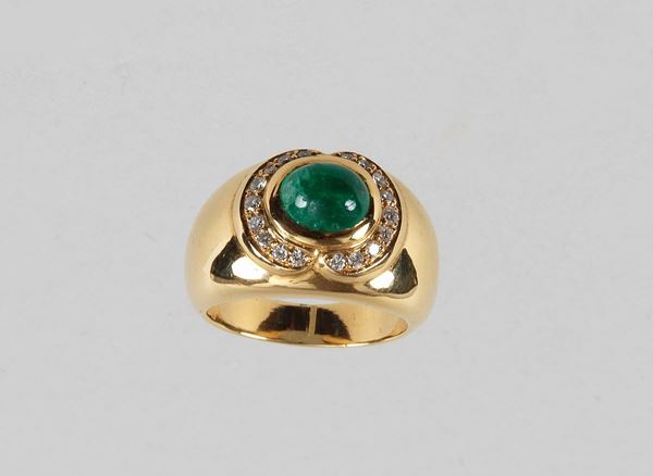 Anello in oro giallo 750 con smeraldo centrale cabochon contornato da diamanti taglio brillante. Gr. 13,50 circa. Diamanti Ct. 0,25 circa. Misura 14.