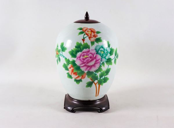 Porcelain potiche with colorful oriental flower motifs and inscriptions on the back, wooden lid