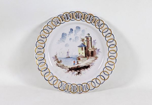 Wall plate in glazed porcelain with painted "Marina with lighthouse and figures" in the center, perforated edge