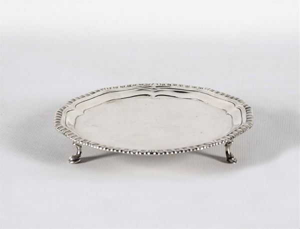 Small round-shaped silver salver with poded edge, supported by three curved feet gr. 190