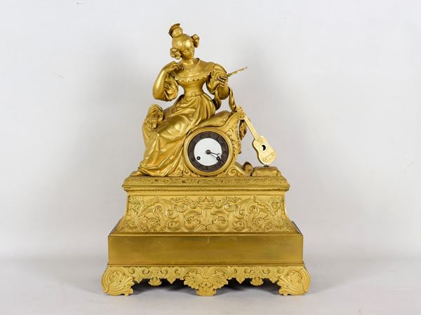 Antique French table clock in gilded and chiseled bronze with a sculpture of a young lady with mirror and guitar