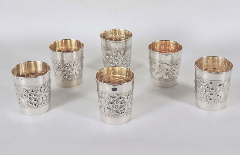 Lotto di sei bicchieri in argento, sbalzati e cesellati a motivi di tralci e grappoli d'uva, inte...