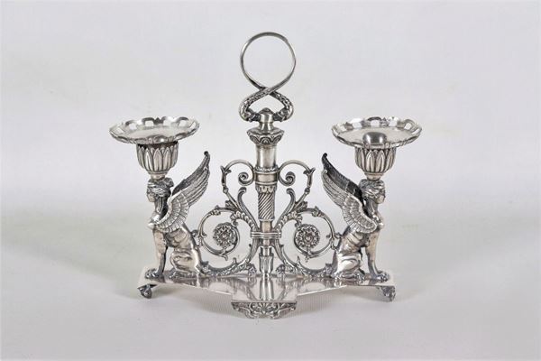Candelabro in argento con sculture di "Vittorie alate", volute floreali e faretra centrale, gr. 1160