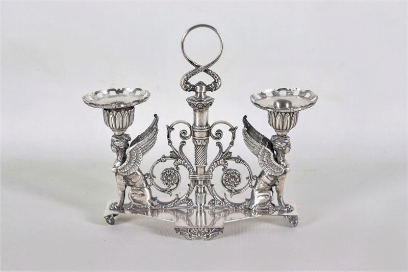 Candelabro in argento con sculture di "Vittorie alate", volute floreali e faretra centrale, gr. 1...