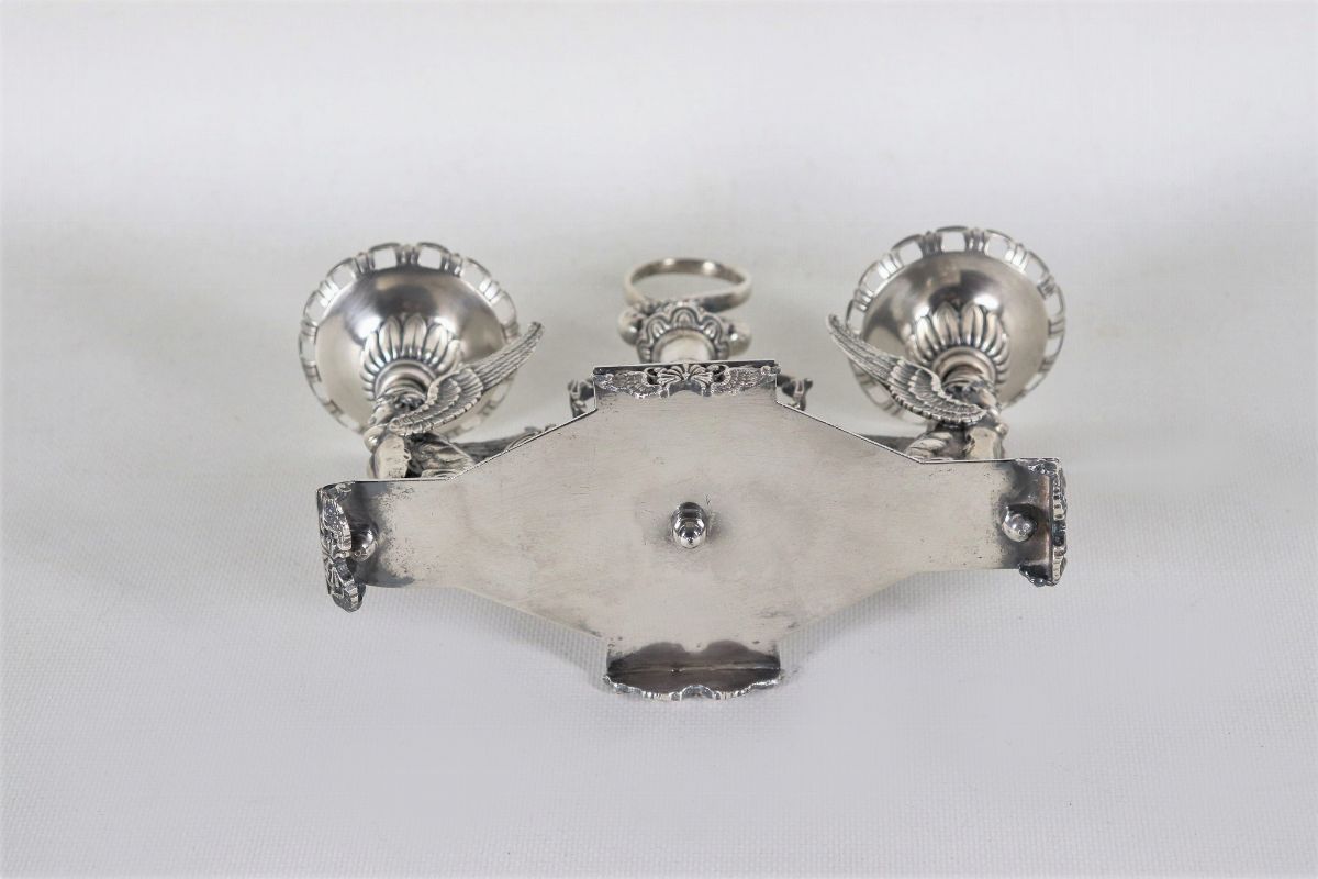 Candelabro in argento con sculture di "Vittorie alate", volute floreali e faretra centrale, gr. 1...