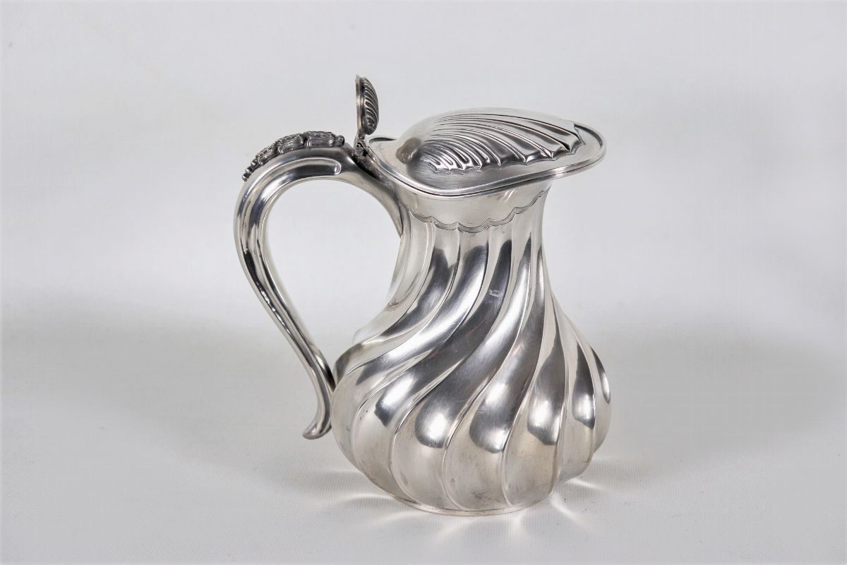 Caraffa in argento sbalzato a torchon con coperchio a forma di conchiglia, gr. 760
