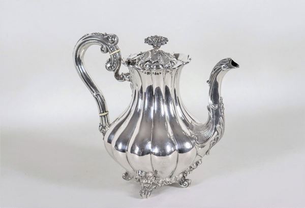 Coffee pot in chiseled and embossed silver, supported by four curved feet and a flower-shaped knob, gr. 810