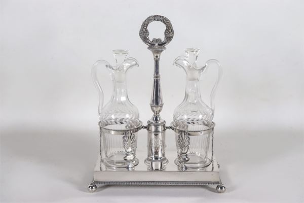 Empire cruet in chiseled and embossed silver with neoclassical palmette motifs and laurel wreaths, two crystal ampoules, gr. 850