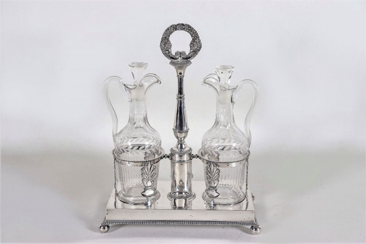 Oliera Impero in argento cesellato e sbalzato a motivi di palmette neoclassiche e corone d'alloro...