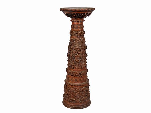 Small patinated terracotta column with floral garlands and relief scrolls