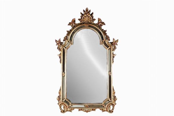 Specchiera di linea Luigi XV in legno dorato e argentato, con intagli a motivi di volute floreali, fiori e conchiglia