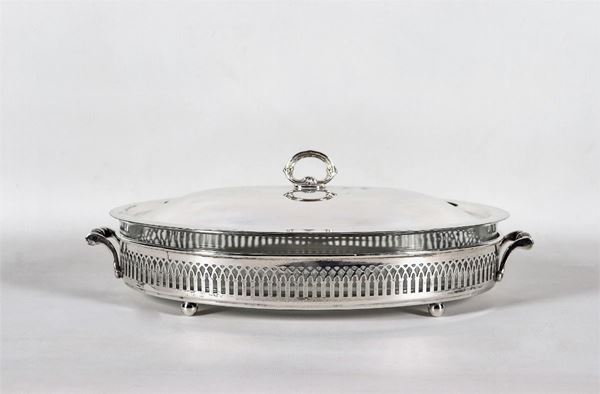 Oval baking dish in silver metal with perforated edge and two handles, supported by four ball feet