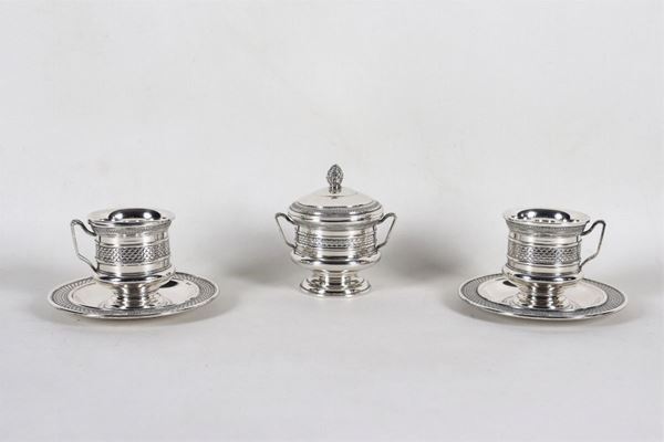 Set in argento cesellato e sbalzato a motivi Impero di una zuccheriera a forma di anfora e due tazze con piattini, gr 670 