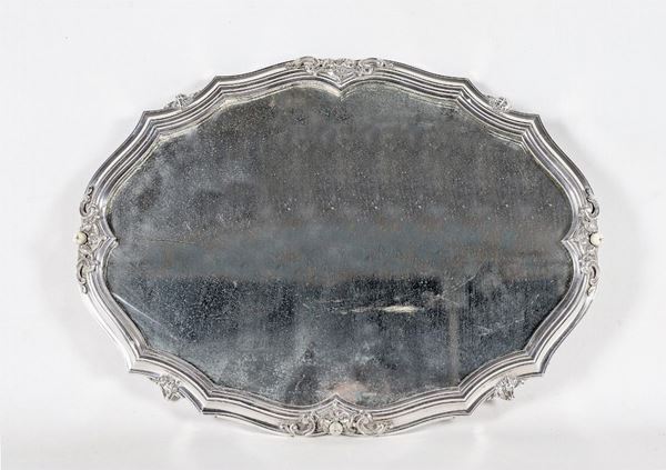 Antico centrotavola ovale in argento, cesellato e sbalzato a motivi Luigi XV con fondo a specchio al mercurio, sorretto da quattro piedini ricurvi