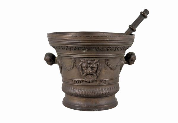 Bronze mortar with pestle and goat heads in relief