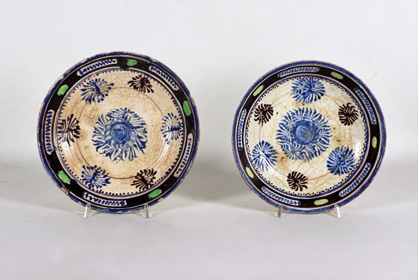 Lot of two antique oriental concave porcelain plates, decorated in blue with stylized flower motifs