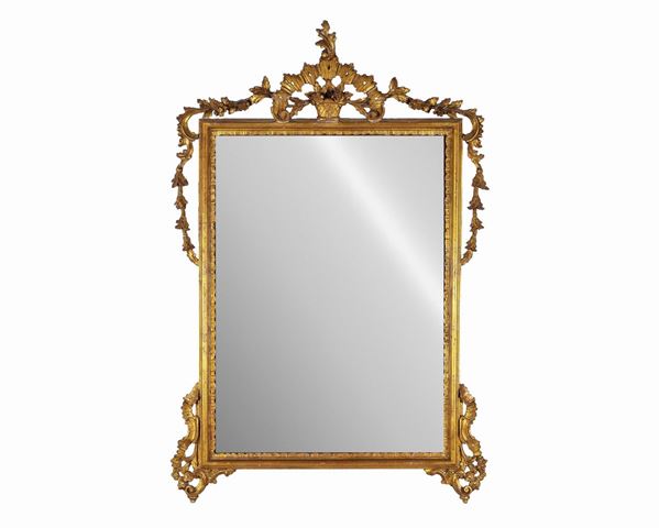 Specchiera di linea Luigi XVI in legno dorato ed intagliato, cimasa a forma di vaso con fiori e specchio al mercurio