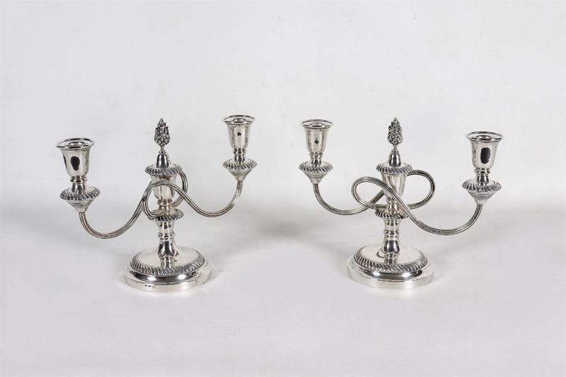 Coppia di candelabri in argento cesellato e sbalzato con bracci tortili, due fiamme ciascuno, gr....