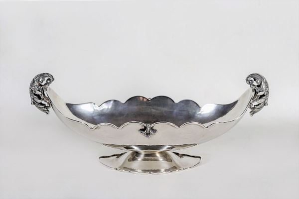 Centrotavola ovale in argento, con bordo frastagliato e due manici cesellati e sbalzati, gr. 600