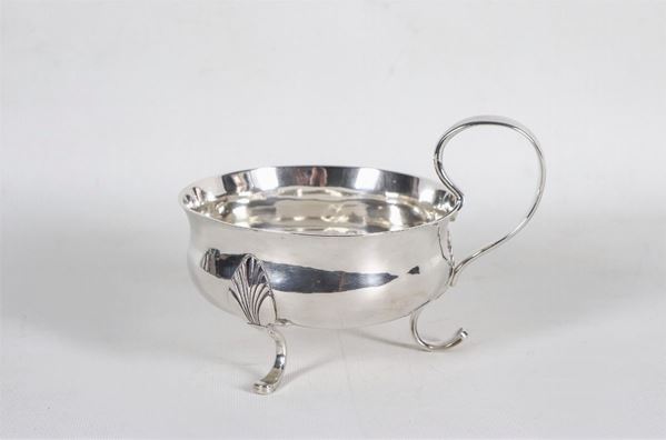 Grande tazza con manico in argento, sorretta da tre piedini ricurvi a motivi Impero, gr. 390