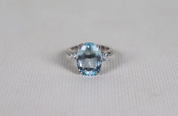 White gold ring with central aquamarine and two small diamonds on the sides. Measure 14.5, gr. 7
