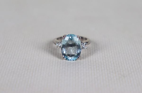 White gold ring with central aquamarine and two small diamonds on the sides. Measure 14.5, gr. 7